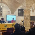 Immagine della conferenza in una sala gremita