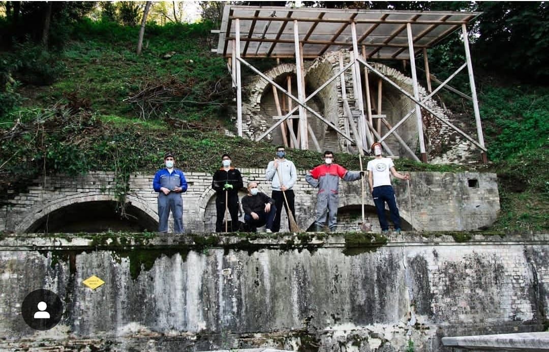 Giovani ripuliscono una fonte antica