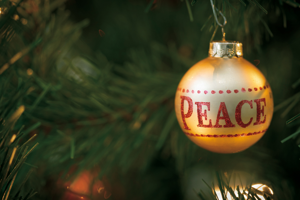 pallina appesa ad albero di Natale con decorata la scritta "peace"